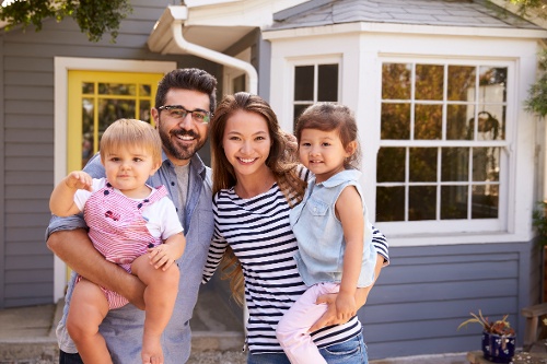 portrait-of-excited-family-standing-outside-new-ho-2021-08-26-16-12-40-utc-1